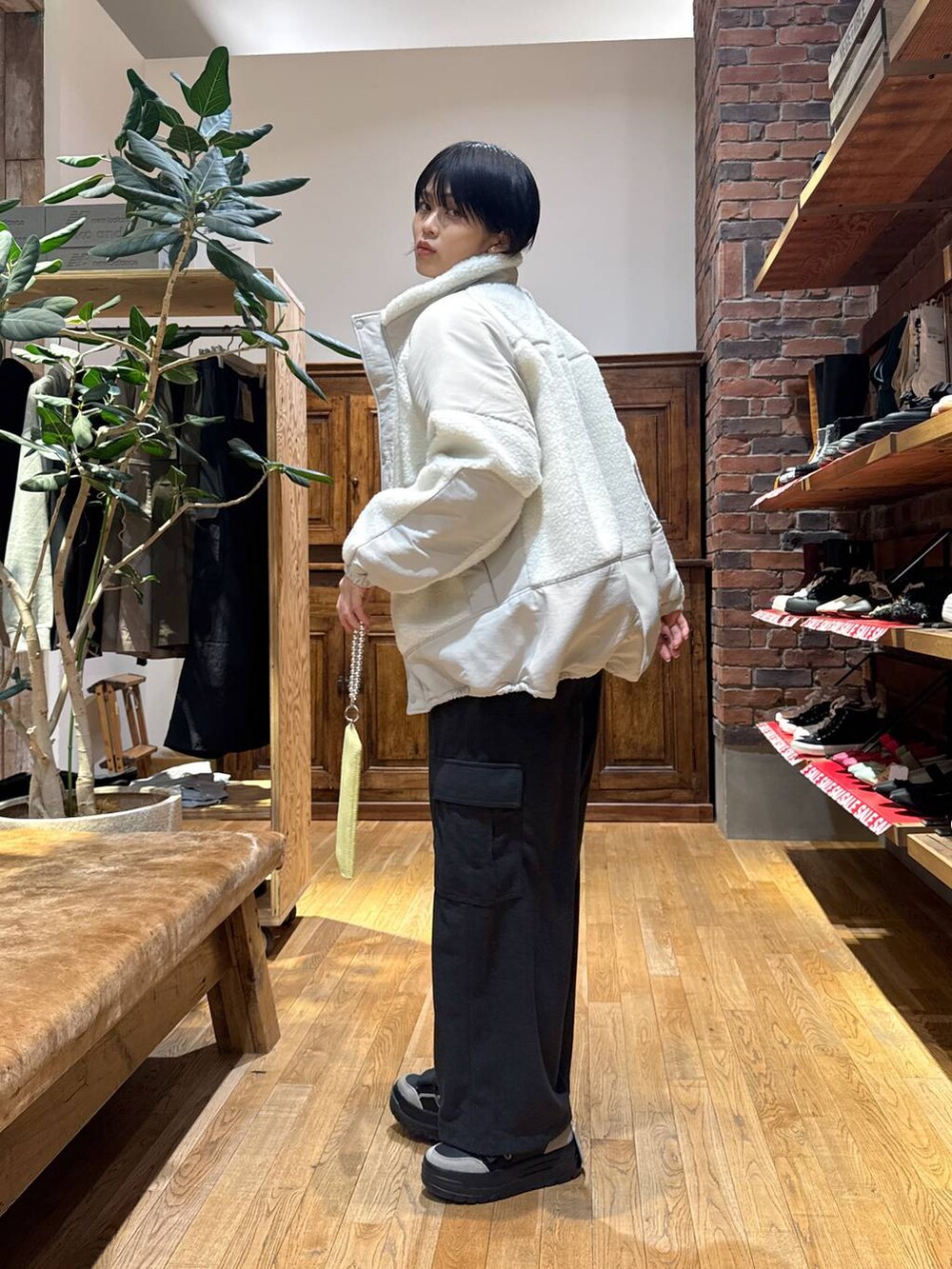 ベージュ系のブルゾン、ブラック系のスニーカー、ブルー系のニット/セーターを着用したレディースの冬コーディネートの4枚目の写真