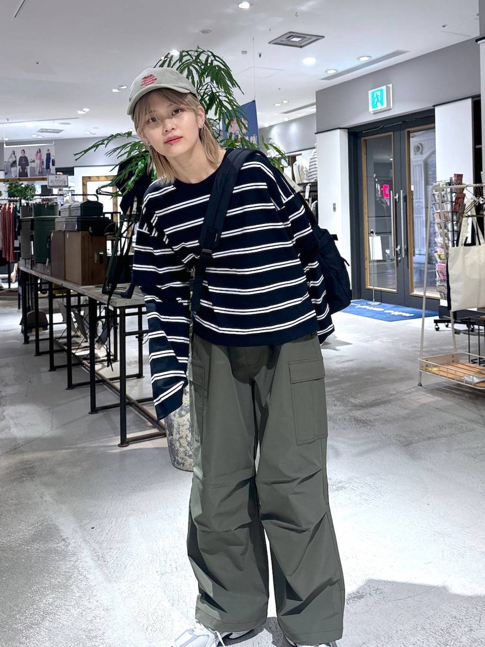 グリーン系のカーゴパンツ、ブラック系のTシャツ/カットソー、グレー系のスニーカーを着用したメンズの春コーディネートの3枚目の写真