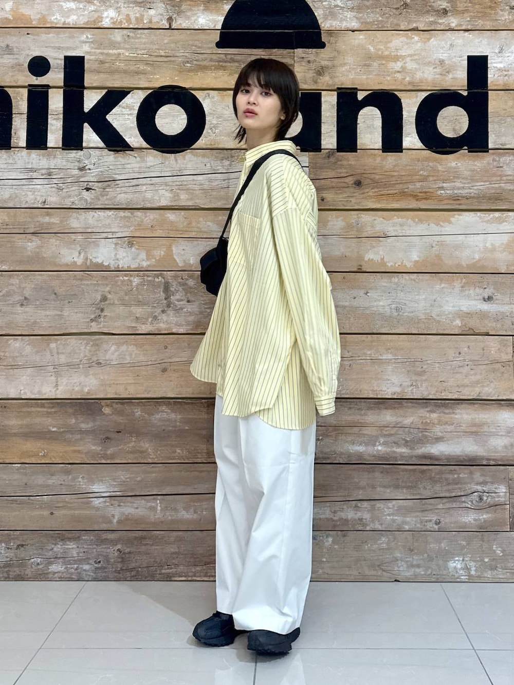 ベージュ系のチノパンツ、イエロー系のシャツ/ブラウス、ブラック系のスニーカーを着用したレディースの冬コーディネートの4枚目の写真