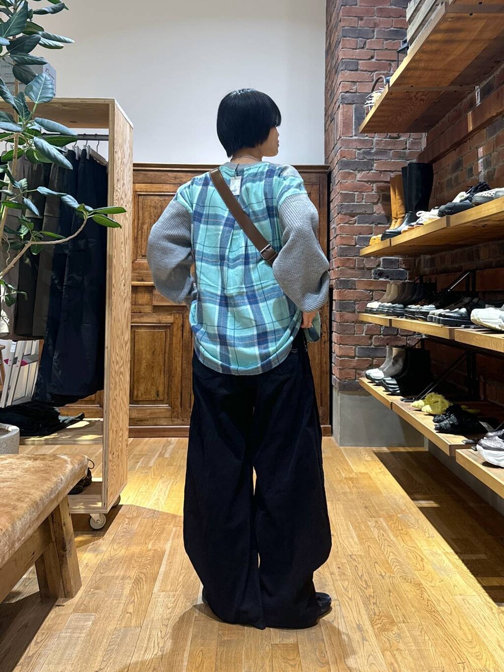 グレー系のスウェット、ブラック系のパンプス、ブラウン系のショルダーバッグを着用したレディースの秋コーディネートの4枚目の写真