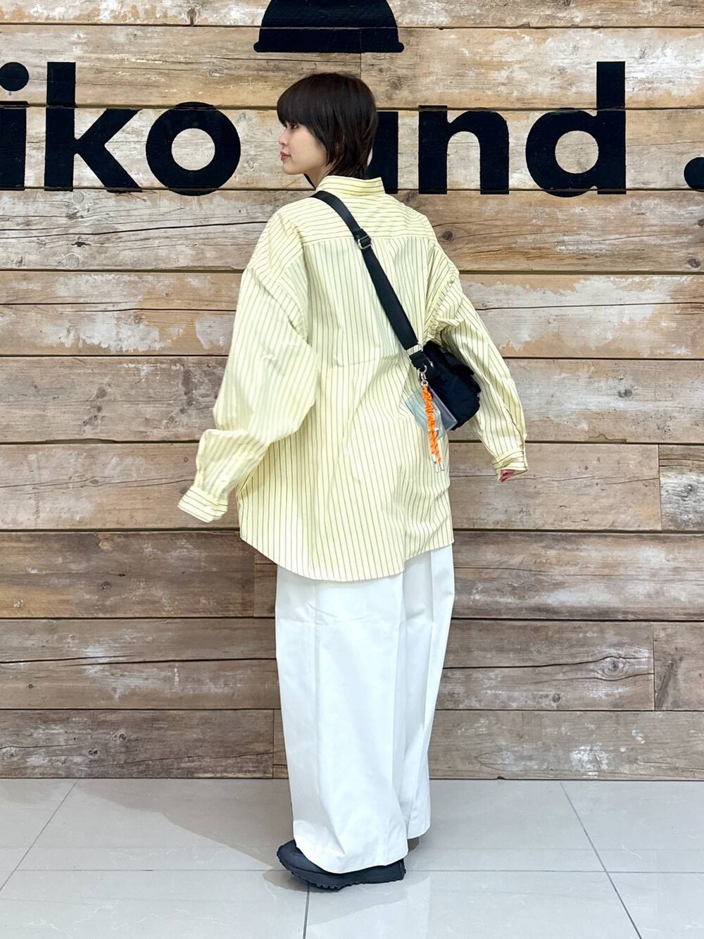 ベージュ系のチノパンツ、イエロー系のシャツ/ブラウス、ブラック系のスニーカーを着用したレディースの冬コーディネートの6枚目の写真