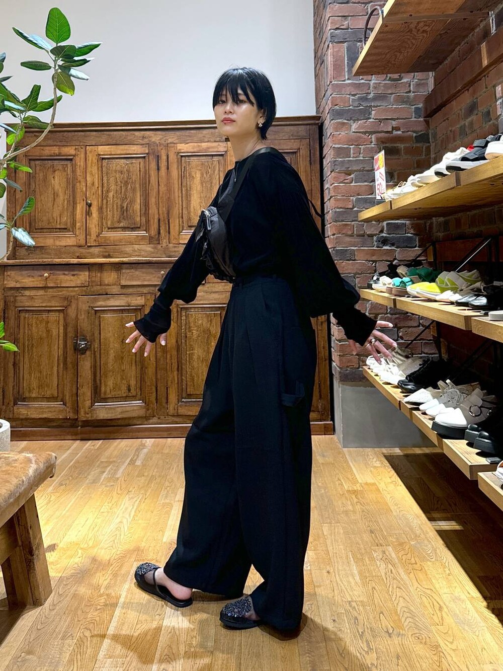 ブラック系のその他パンツ、ブラック系のTシャツ/カットソー、ブラック系のボディバッグ/ウエストポーチを着用したレディースの秋コーディネートの2枚目の写真