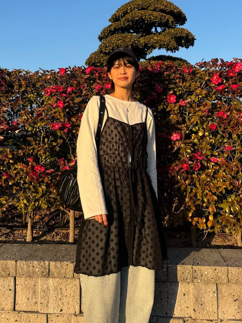 ホワイト系のTシャツ/カットソー、ブラック系のショルダーバッグ、ブラック系のワンピースを着用したレディースの冬コーディネートの4枚目の写真