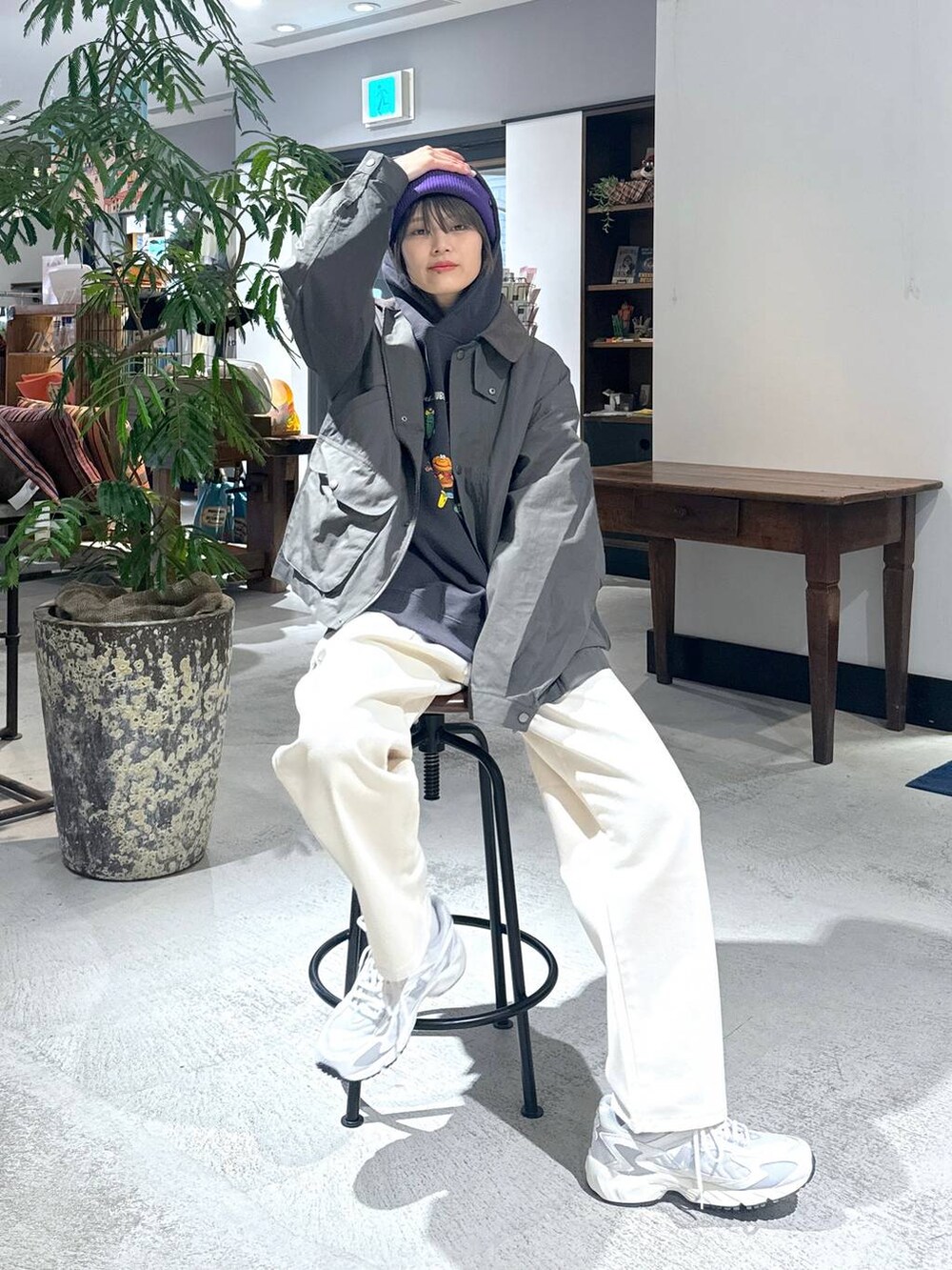 ホワイト系のスニーカー、ホワイト系のデニムパンツ、グレー系のパーカーを着用したレディースの冬コーディネートの2枚目の写真