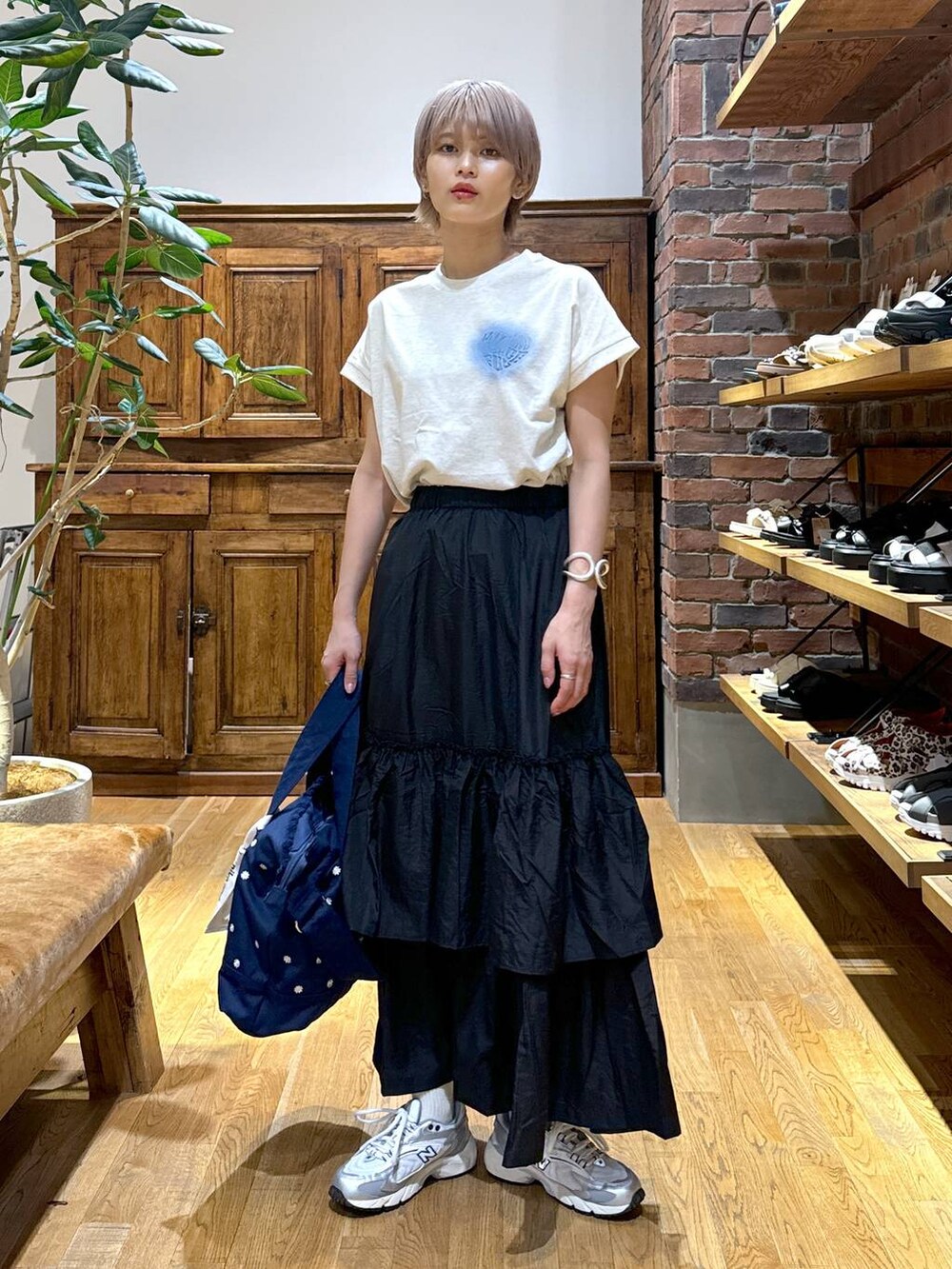 ブルー系のショルダーバッグ、グレー系のスニーカー、ブラック系のスカートを着用したレディースの夏コーディネートの3枚目の写真