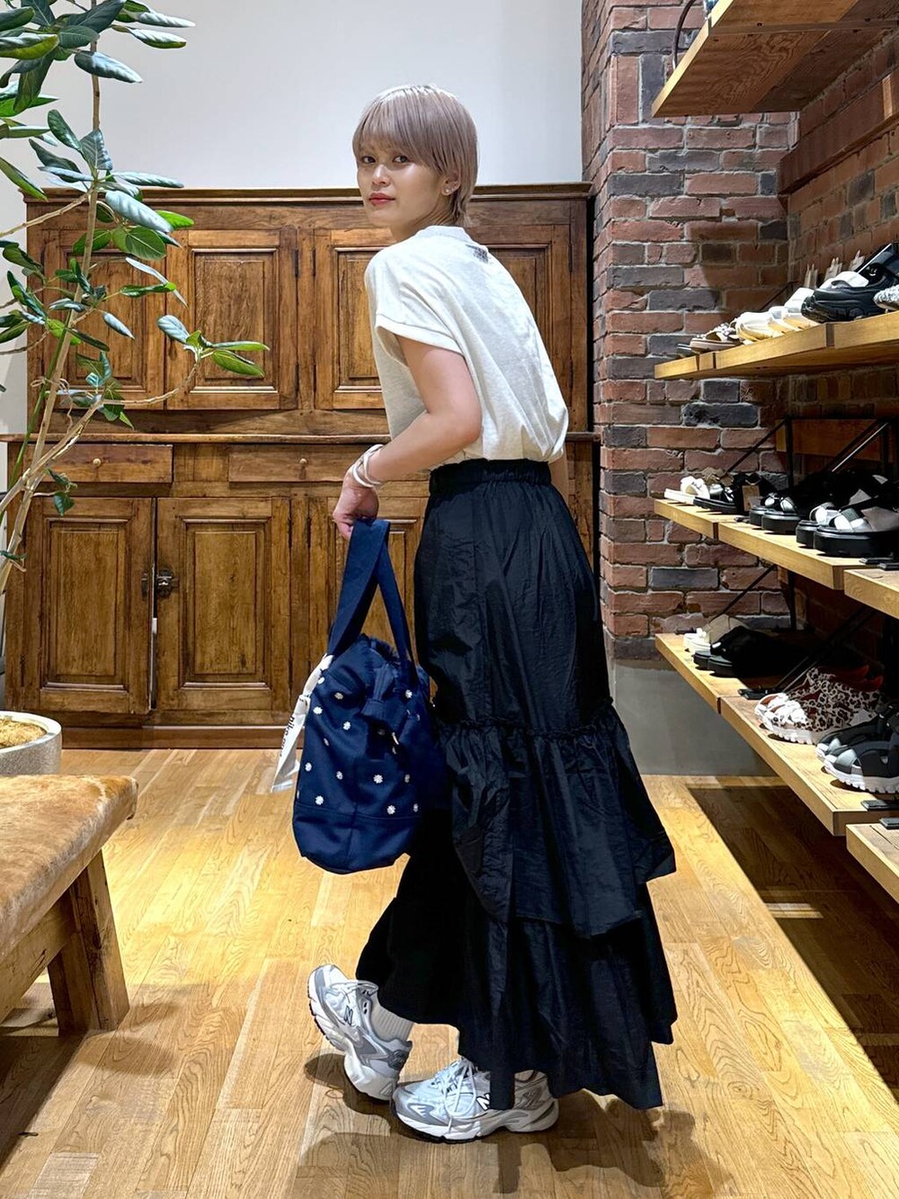 ブルー系のショルダーバッグ、グレー系のスニーカー、ブラック系のスカートを着用したレディースの夏コーディネートの4枚目の写真