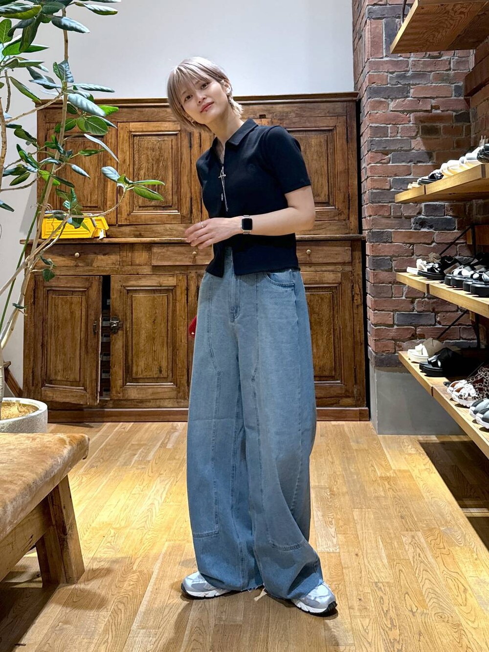 グレー系のスニーカー、ブラック系のカーディガン/ボレロ、レッド系の財布を着用したレディースの夏コーディネートの3枚目の写真