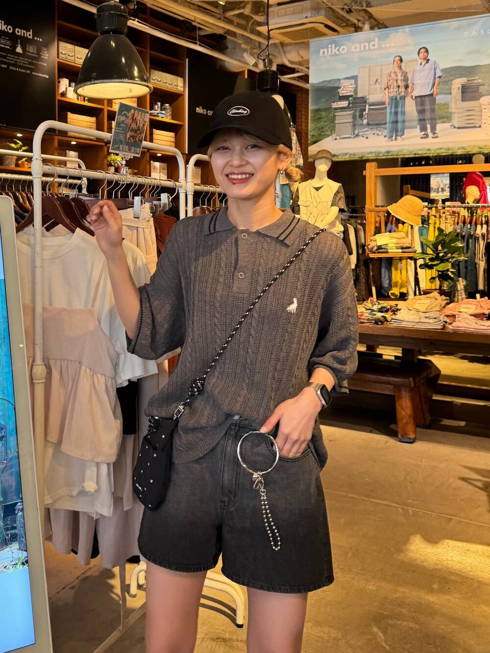 ブラック系のショルダーバッグ、ブラック系のサンダル、ブラック系のキャップを着用したレディースの春コーディネートの4枚目の写真