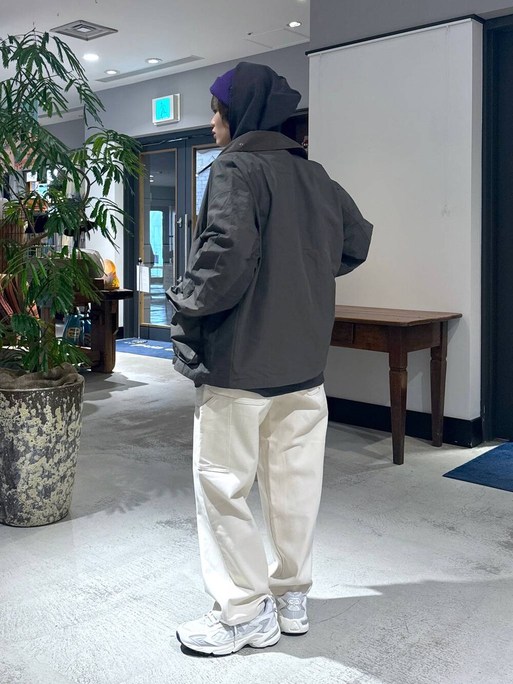 ホワイト系のスニーカー、ホワイト系のデニムパンツ、グレー系のパーカーを着用したレディースの冬コーディネートの4枚目の写真