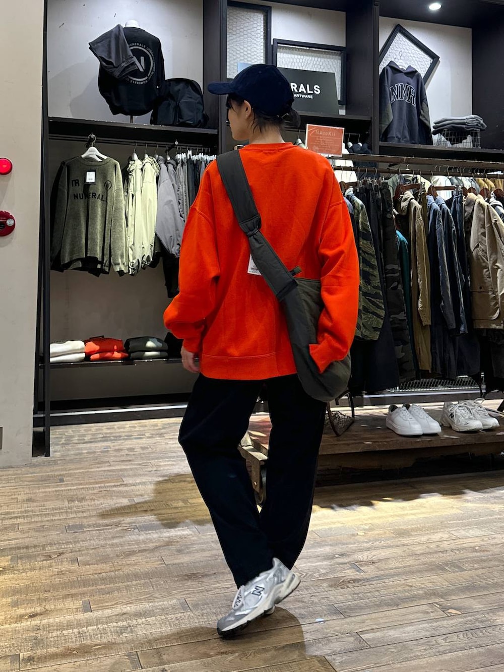 グレー系のスニーカー、ブラック系のその他パンツ、オレンジ系のスウェットを着用したメンズの秋コーディネートの3枚目の写真