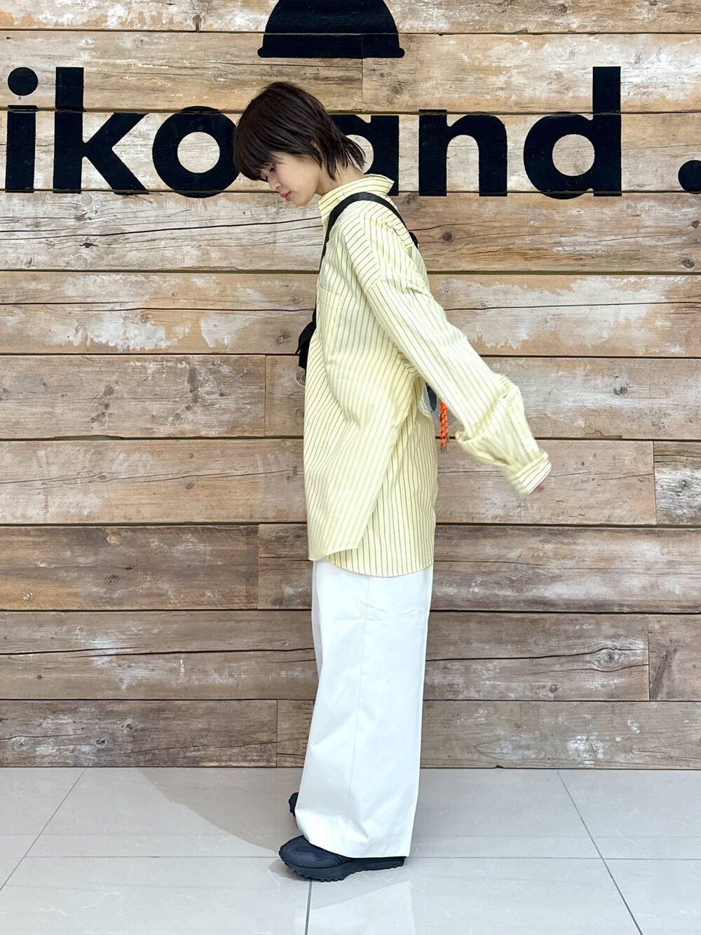 ベージュ系のチノパンツ、イエロー系のシャツ/ブラウス、ブラック系のスニーカーを着用したレディースの冬コーディネートの7枚目の写真