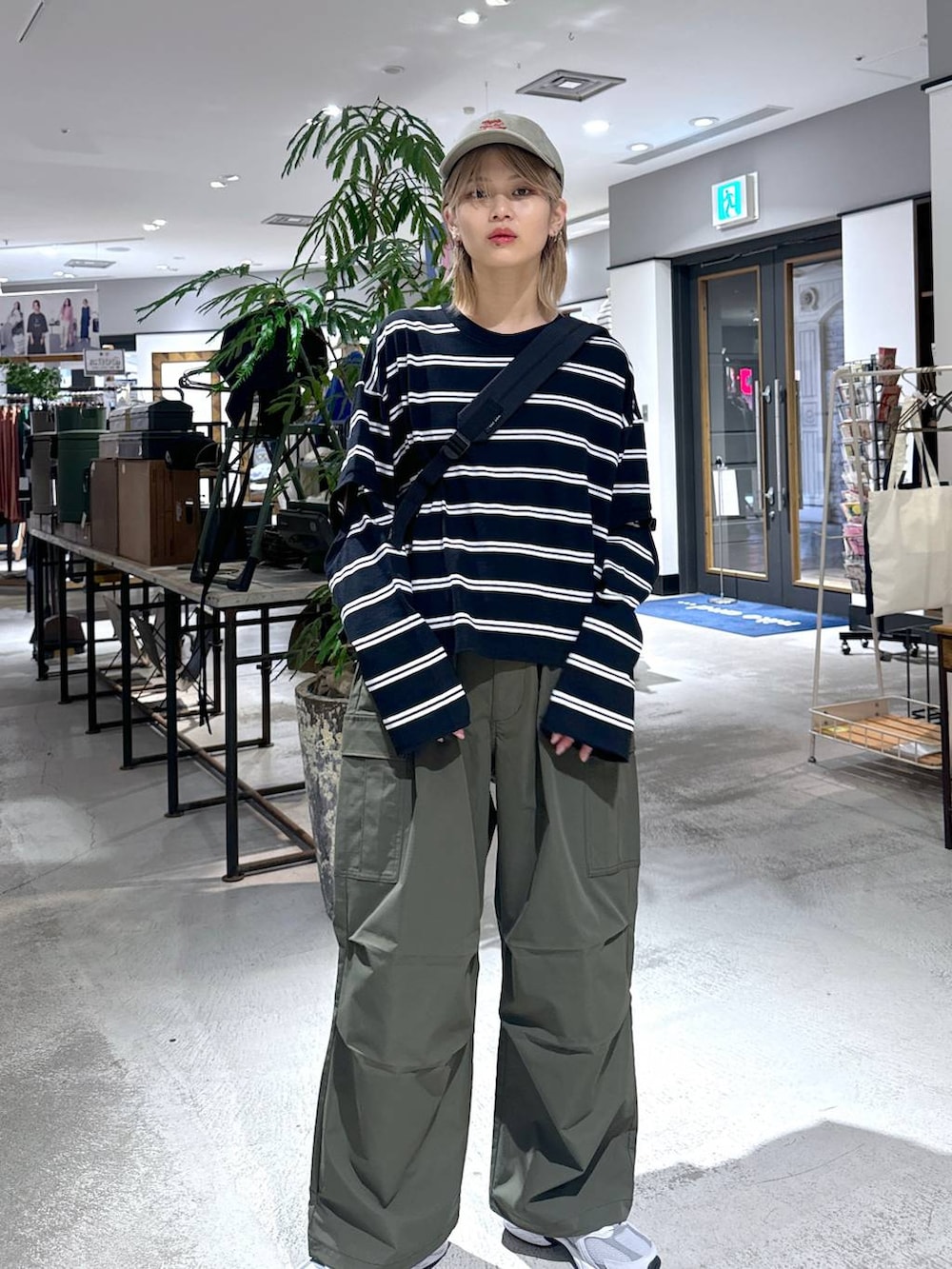 グリーン系のカーゴパンツ、ブラック系のTシャツ/カットソー、グレー系のスニーカーを着用したメンズの春コーディネートの4枚目の写真