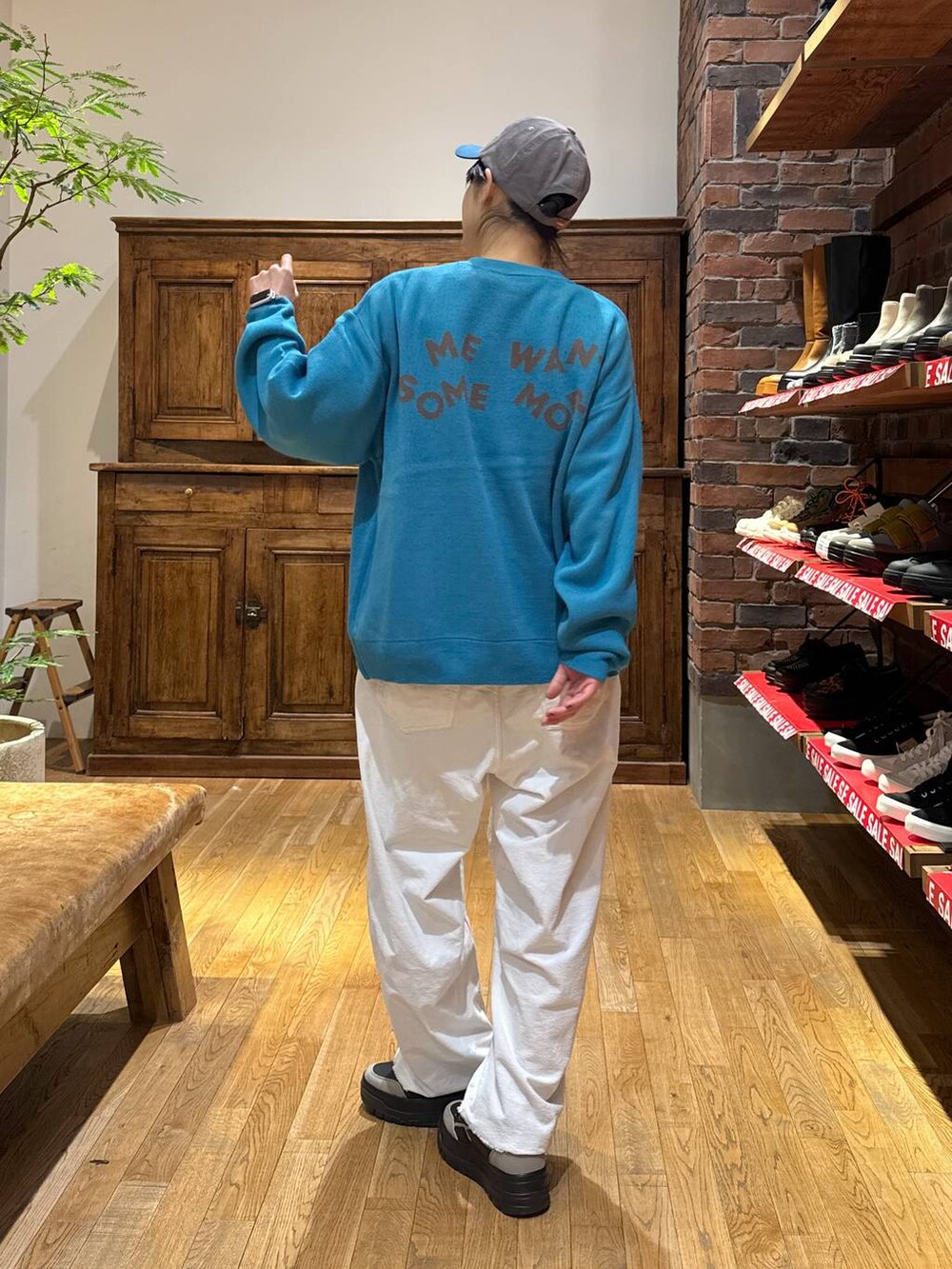 ホワイト系のその他パンツ、ブラック系のスニーカー、ブルー系のニット/セーターを着用したレディースの冬コーディネートの4枚目の写真