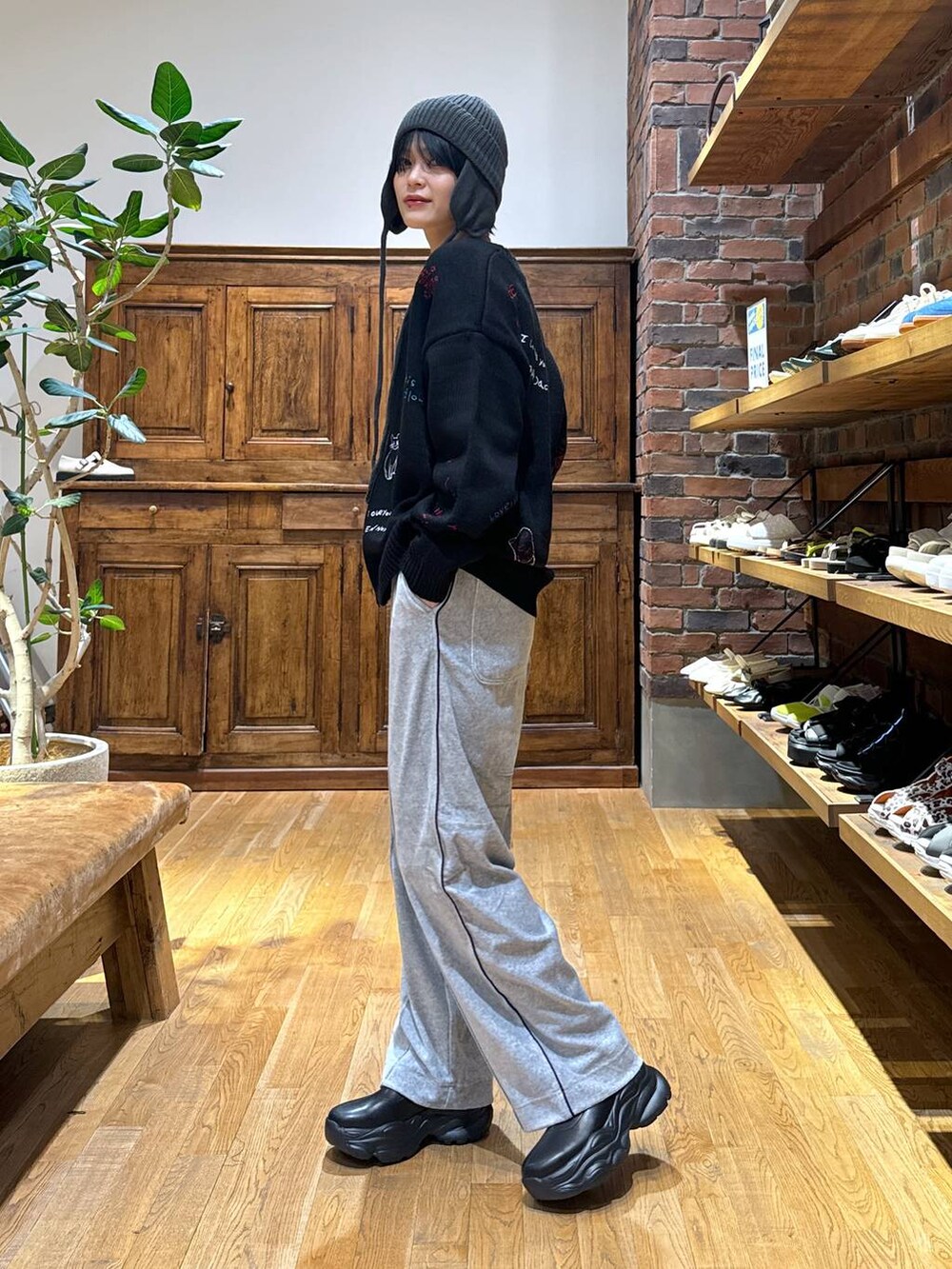 グレー系のその他パンツ、ブラック系のブーツ、ブラック系のカーディガン/ボレロを着用したレディースの秋コーディネートの3枚目の写真