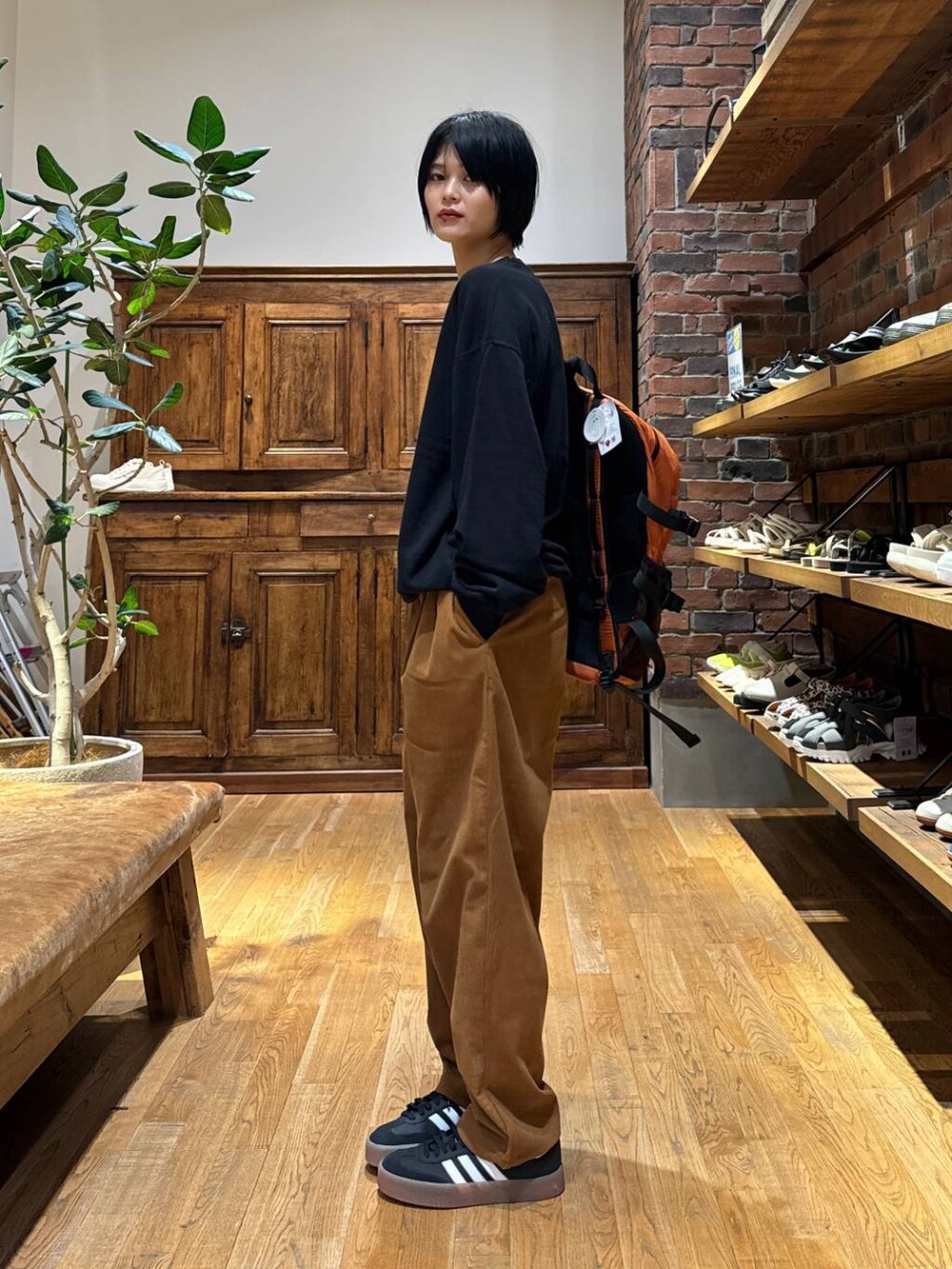ブラック系のスニーカー、イエロー系のその他パンツ、ブラック系のスウェットを着用したレディースの秋コーディネートの3枚目の写真