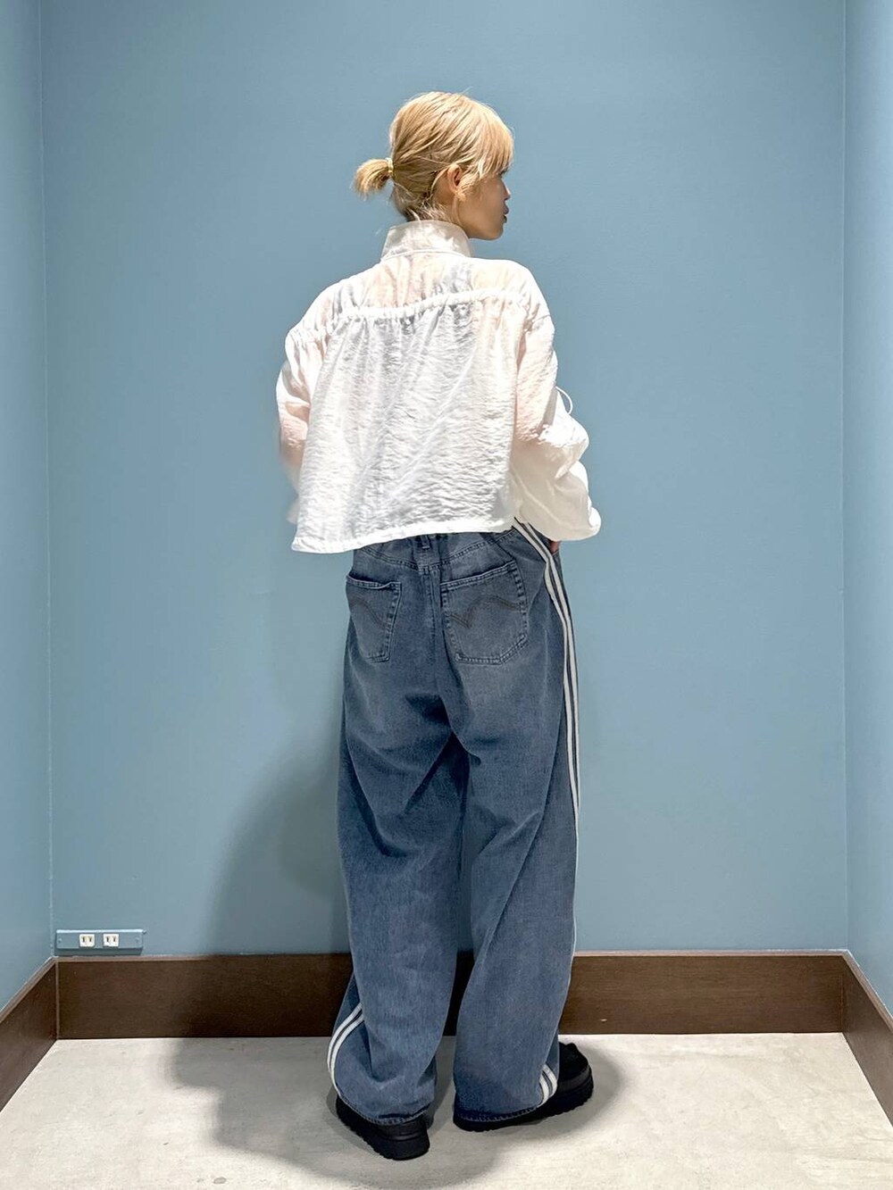 ベージュ系のタンクトップ、ホワイト系のブルゾンを着用したレディースの春コーディネートの2枚目の写真