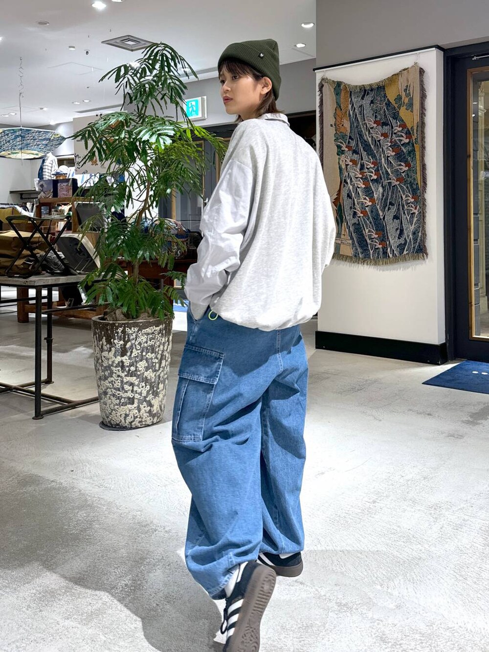 ブルー系のデニムパンツ、グリーン系のニットキャップ/ビーニーを着用したレディースの冬コーディネートの5枚目の写真