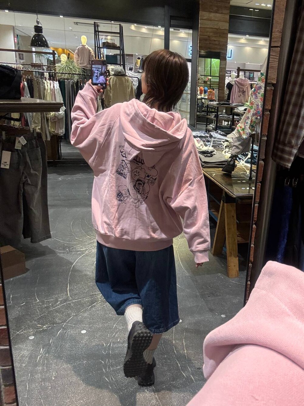 ブルー系のデニムパンツ、ブラック系のスニーカー、ピンク系のパーカーを着用したレディースの冬コーディネートの7枚目の写真