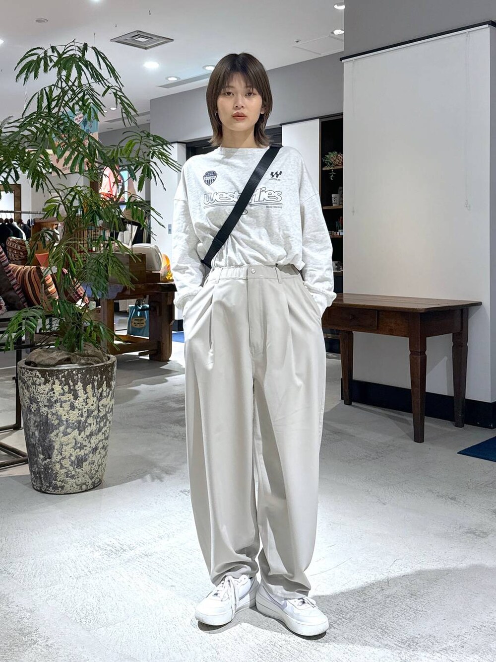 ベージュ系のTシャツ/カットソー、ベージュ系のスラックス、ブラック系のボディバッグ/ウエストポーチを着用したレディースの冬コーディネートの4枚目の写真