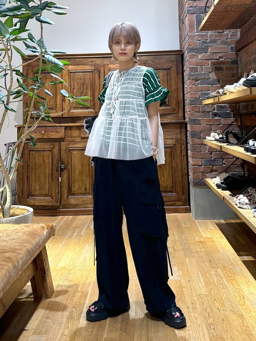 ブラック系のサンダル、ブラック系のカーゴパンツ、ホワイト系のベストを着用したレディースの夏コーディネートの4枚目の写真