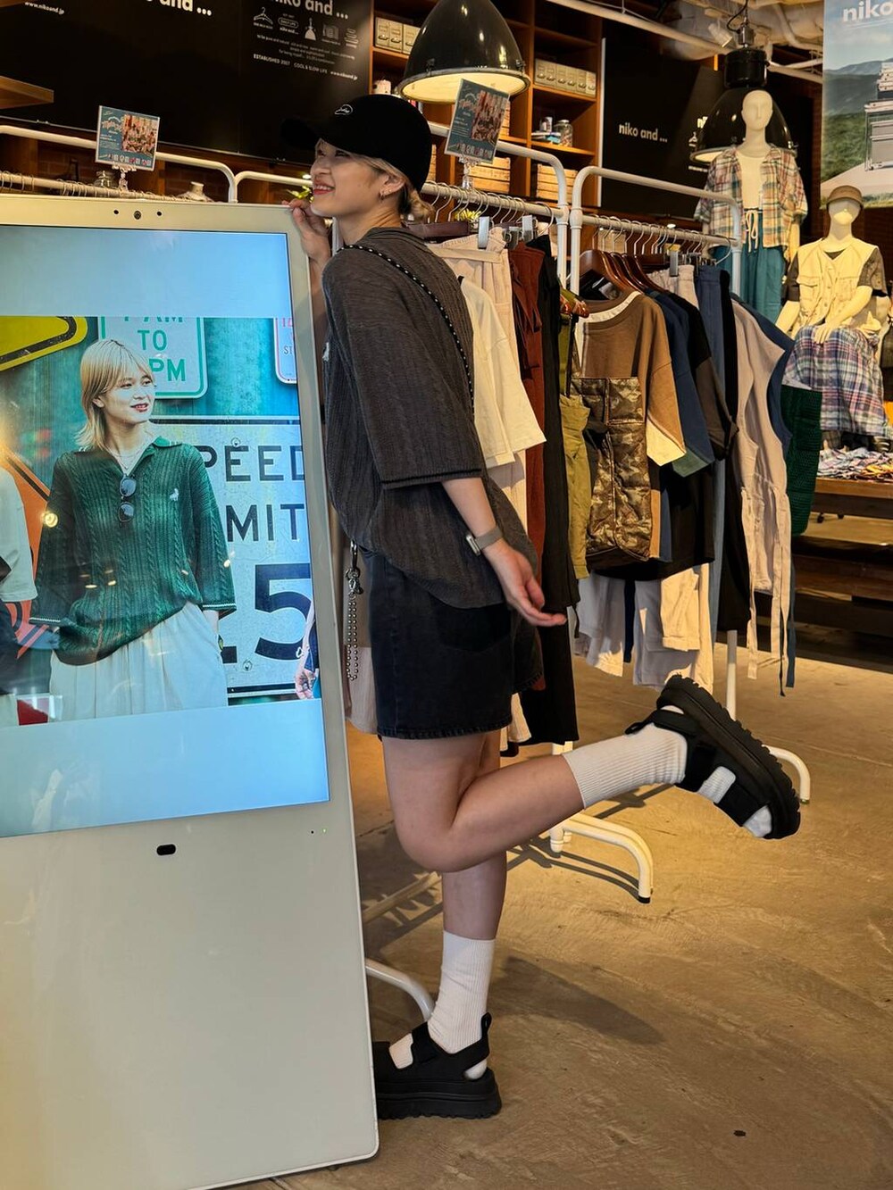 ブラック系のショルダーバッグ、ブラック系のサンダル、ブラック系のキャップを着用したレディースの春コーディネートの2枚目の写真