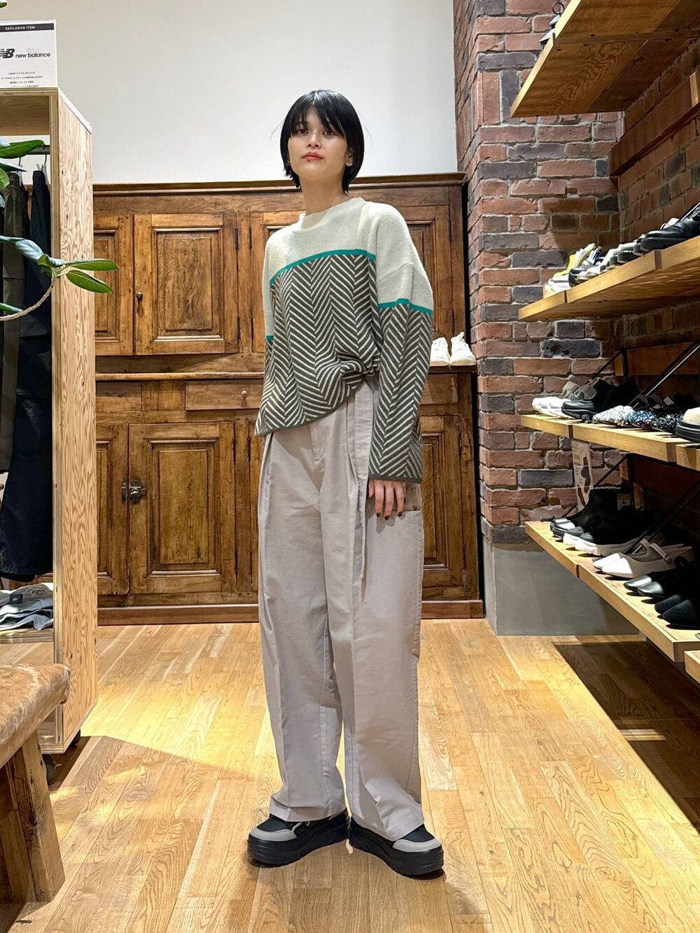 ベージュ系のその他パンツ、ブラウン系のニット/セーター、ブラック系のスニーカーを着用したレディースの冬コーディネートの2枚目の写真