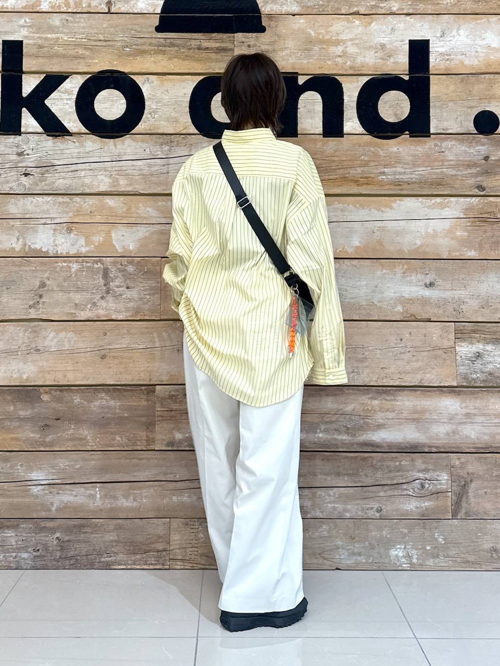 ベージュ系のチノパンツ、イエロー系のシャツ/ブラウス、ブラック系のスニーカーを着用したレディースの冬コーディネートの3枚目の写真