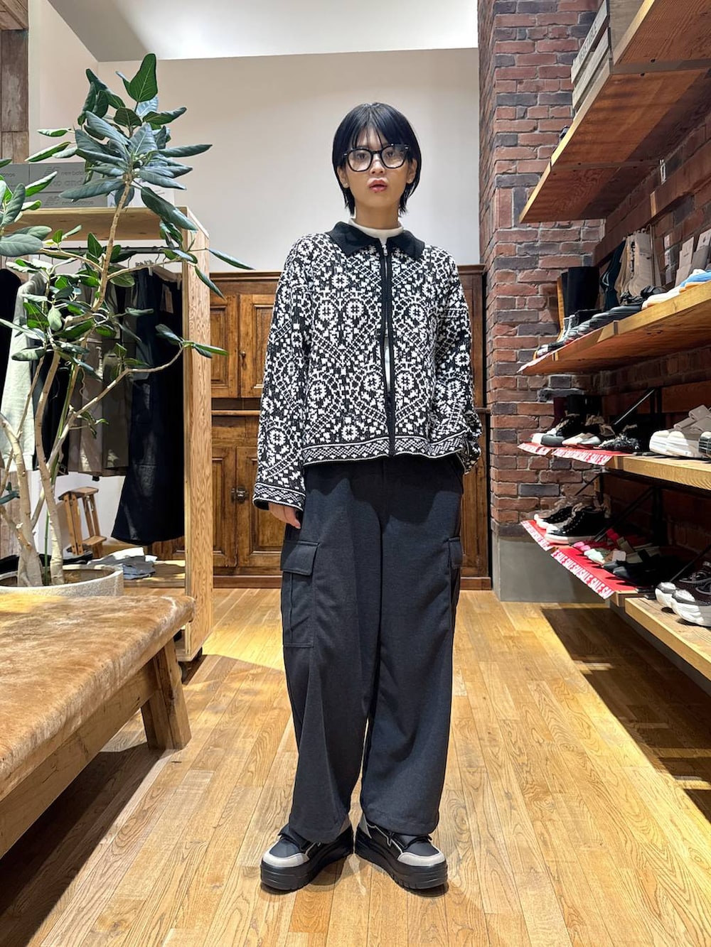 ブラック系のスニーカー、グレー系のカーゴパンツ、ブラック系のカーディガン/ボレロを着用したレディースの冬コーディネートの3枚目の写真