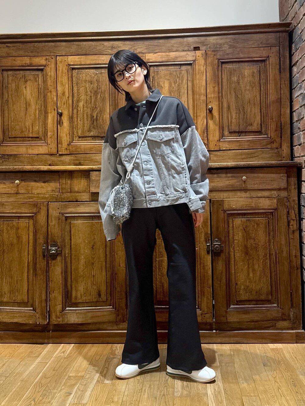 グレー系のデニムジャケット、ブラック系のショルダーバッグ、ブラック系のその他パンツを着用したレディースの冬コーディネートの4枚目の写真