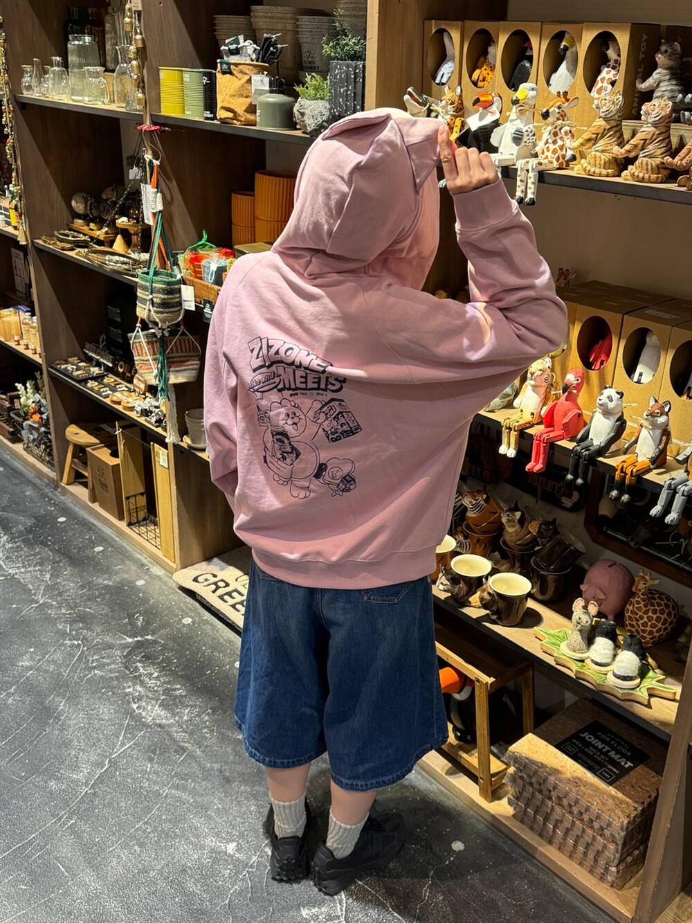 ブルー系のデニムパンツ、ブラック系のスニーカー、ピンク系のパーカーを着用したレディースの冬コーディネートの3枚目の写真
