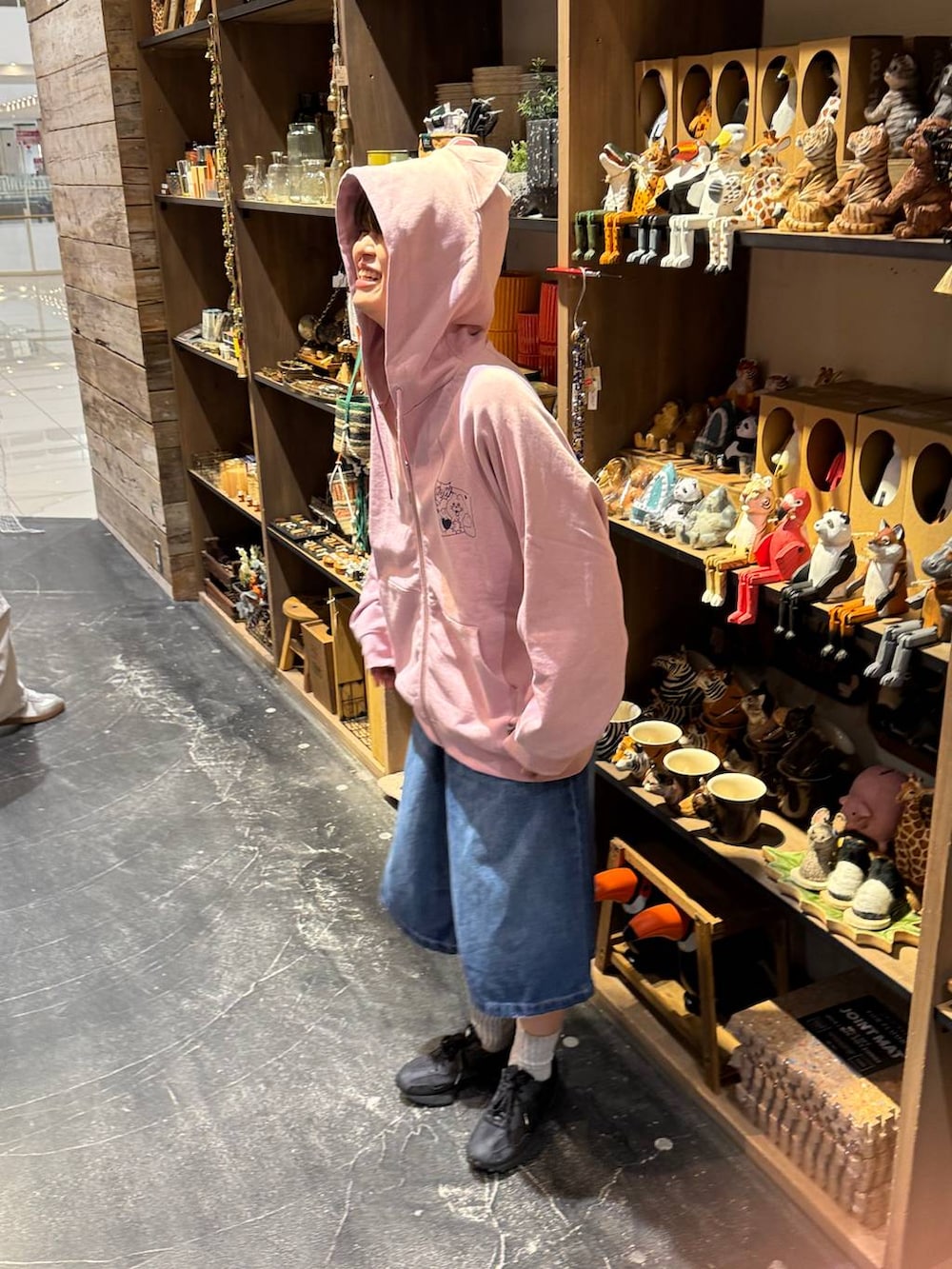 ブルー系のデニムパンツ、ブラック系のスニーカー、ピンク系のパーカーを着用したレディースの冬コーディネートの2枚目の写真