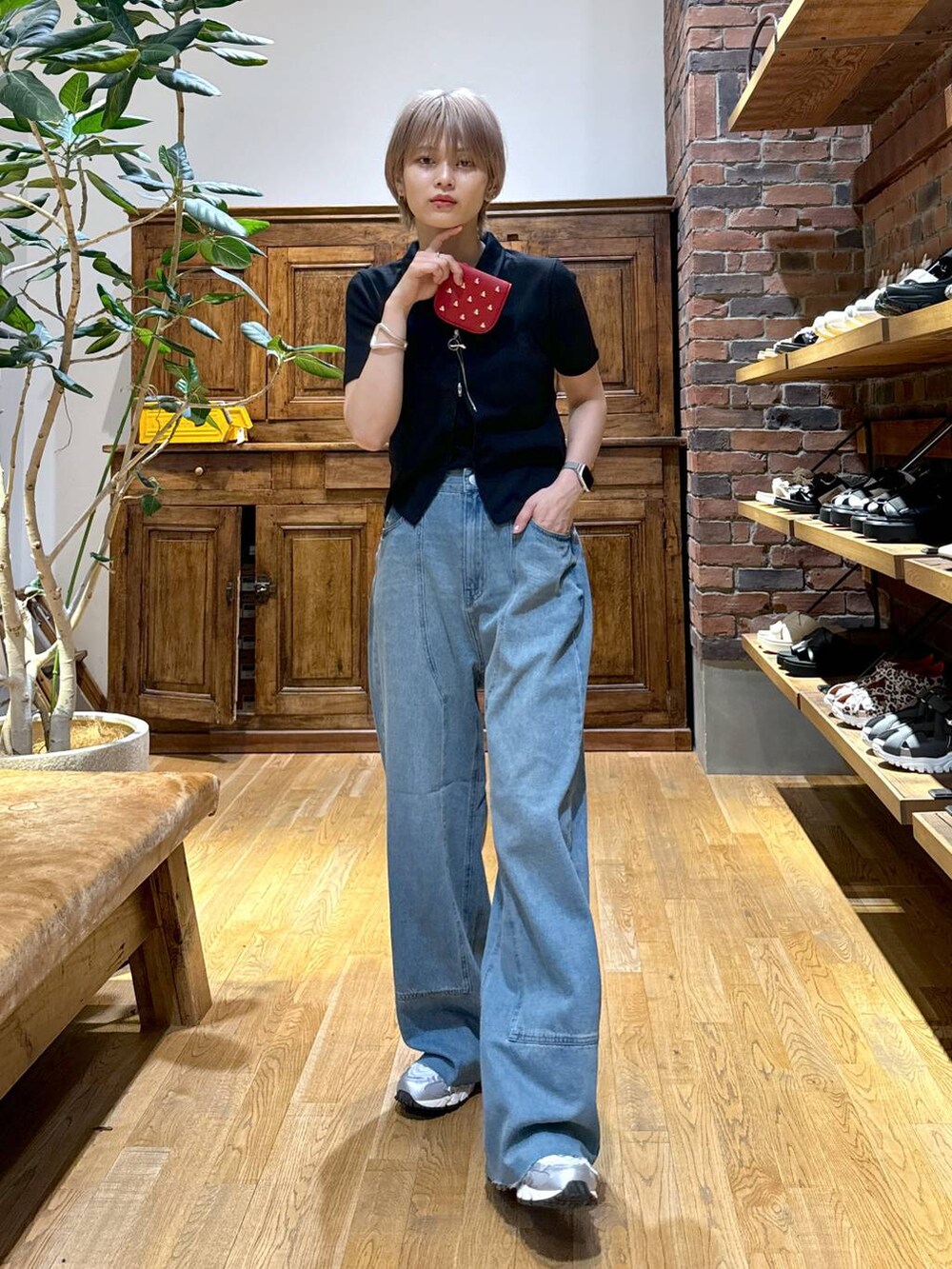 グレー系のスニーカー、ブラック系のカーディガン/ボレロ、レッド系の財布を着用したレディースの夏コーディネートの4枚目の写真