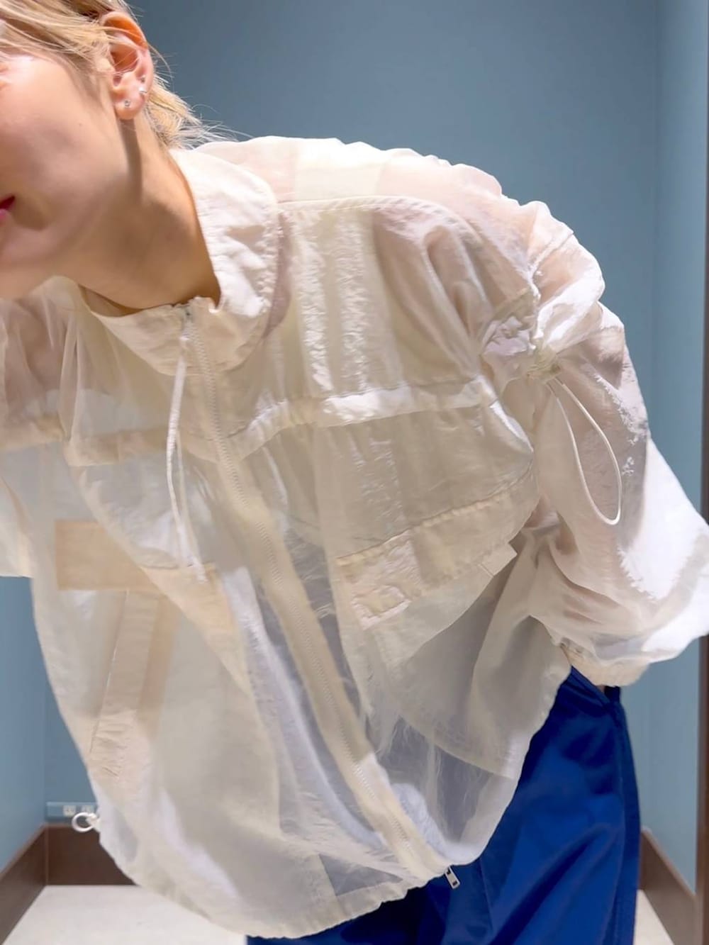 ベージュ系のタンクトップ、ブルー系のその他パンツ、ホワイト系のブルゾンを着用したレディースの春コーディネートの4枚目の写真