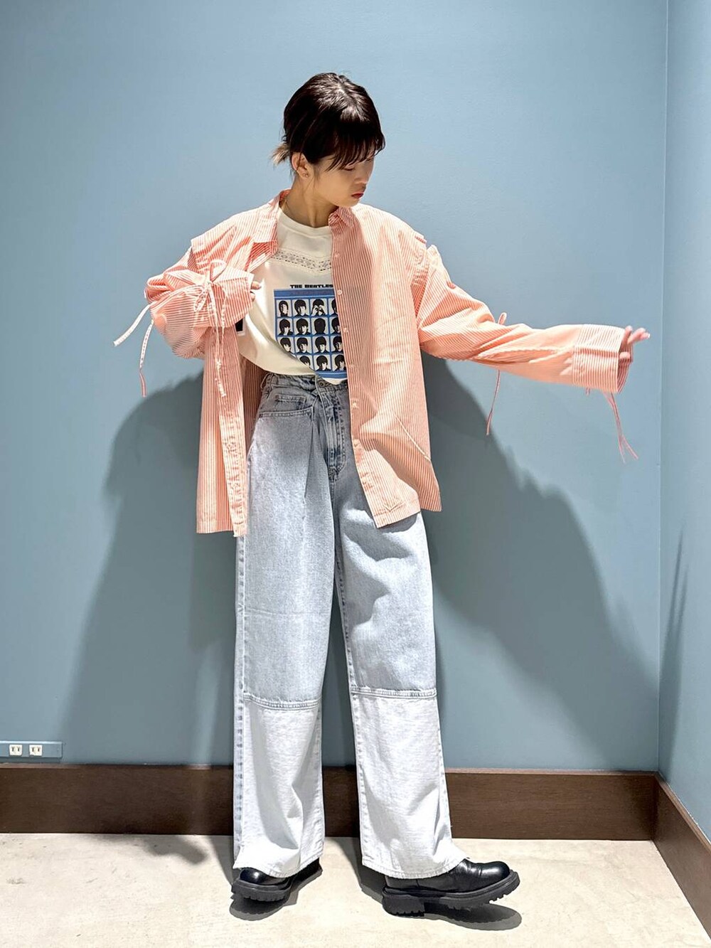 オレンジ系のシャツ/ブラウス、ホワイト系のTシャツ/カットソー、ブルー系のデニムパンツを着用したレディースの春コーディネートの2枚目の写真