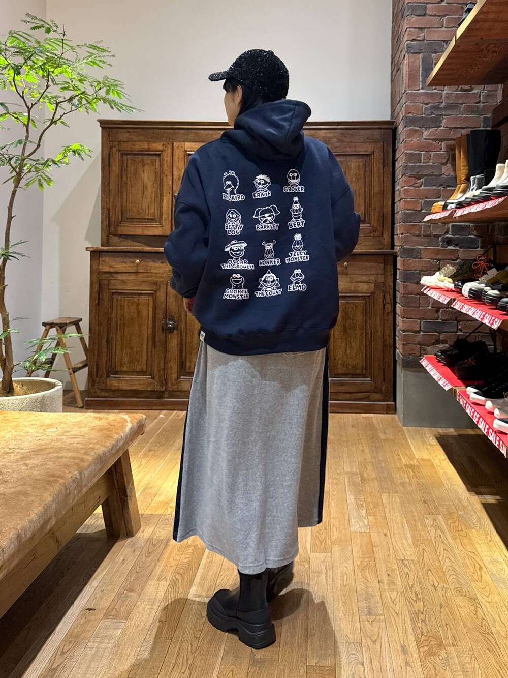 ブラック系のブーツ、ブルー系のパーカー、ブラック系のキャップを着用したレディースの冬コーディネートの3枚目の写真