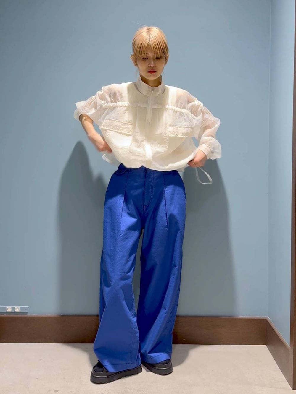 ベージュ系のタンクトップ、ブルー系のその他パンツ、ホワイト系のブルゾンを着用したレディースの春コーディネートの6枚目の写真