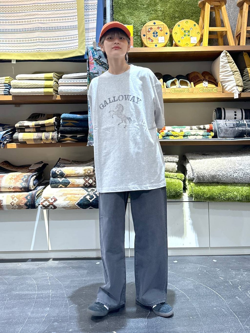 グレー系のデニムパンツ、グレー系のTシャツ/カットソー、オレンジ系のキャップを着用したメンズの夏コーディネートの3枚目の写真