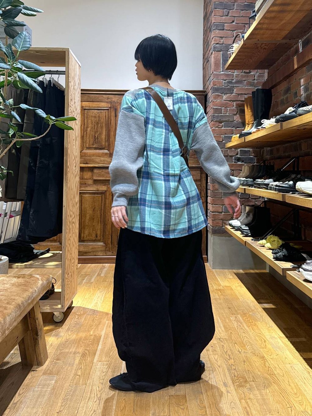 グレー系のスウェット、ブラック系のパンプス、ブラウン系のショルダーバッグを着用したレディースの秋コーディネートの5枚目の写真