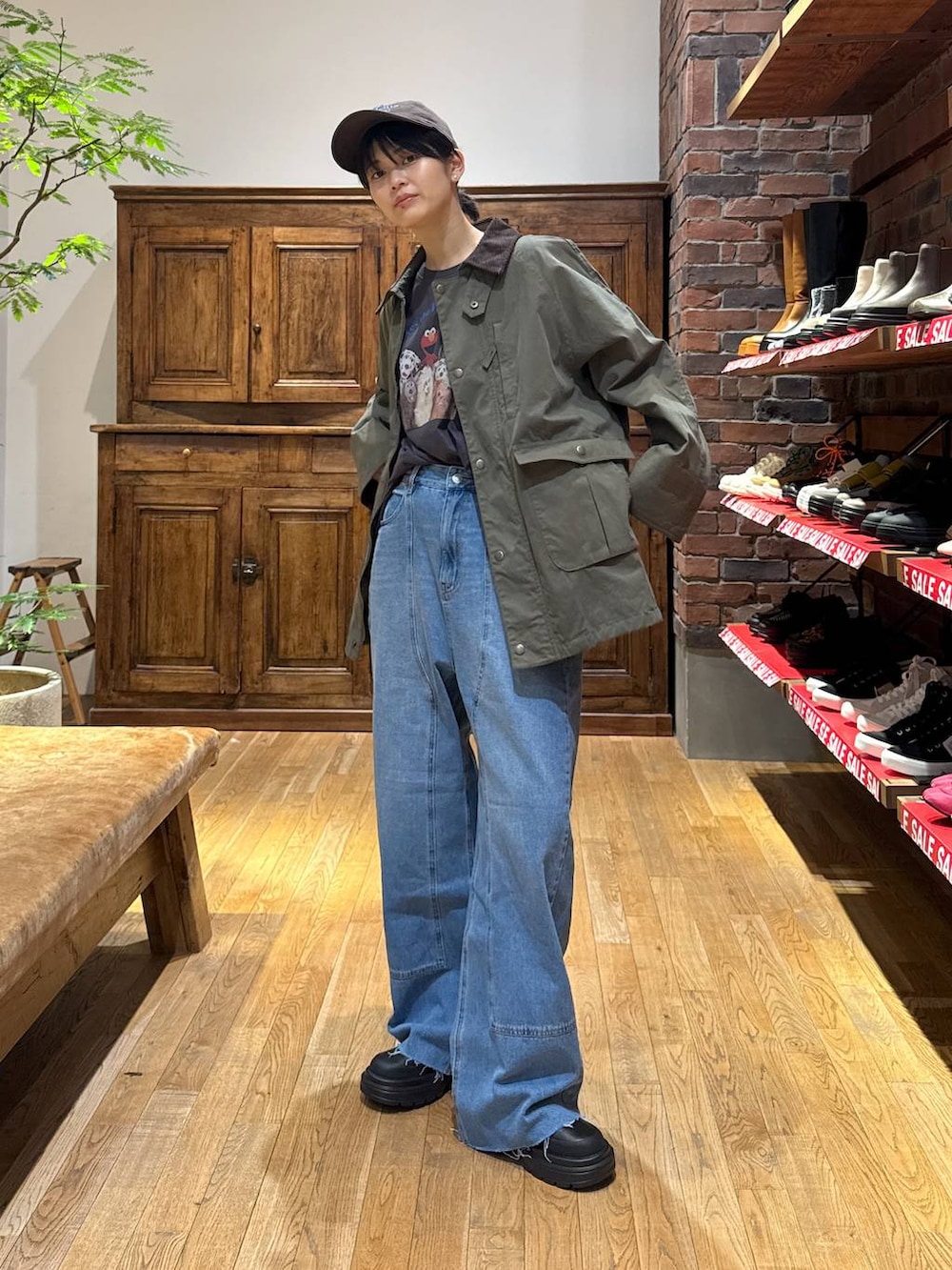 グリーン系のブルゾン、グレー系のTシャツ/カットソーを着用したレディースの冬コーディネートの2枚目の写真