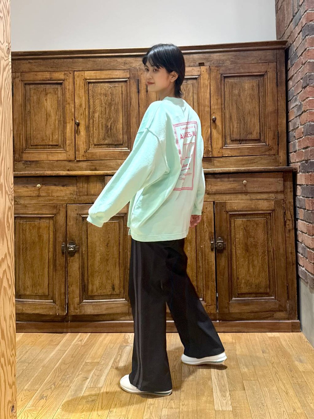 ホワイト系のブルゾン、ブルー系のニット/セーター、グリーン系のTシャツ/カットソーを着用したレディースの冬コーディネートの7枚目の写真