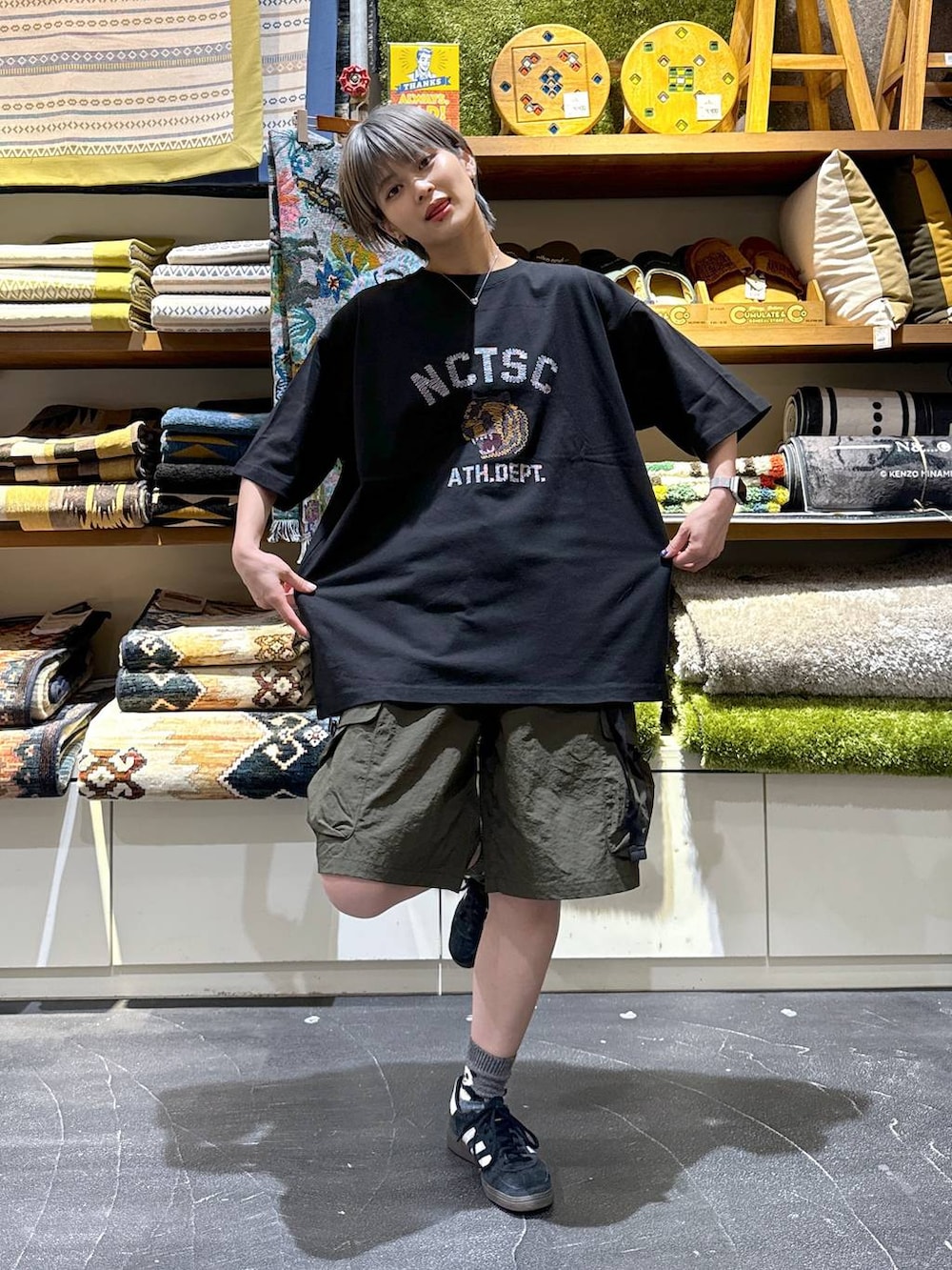 グリーン系のカーゴパンツ、ブラック系のTシャツ/カットソーを着用したレディースの夏コーディネートの2枚目の写真