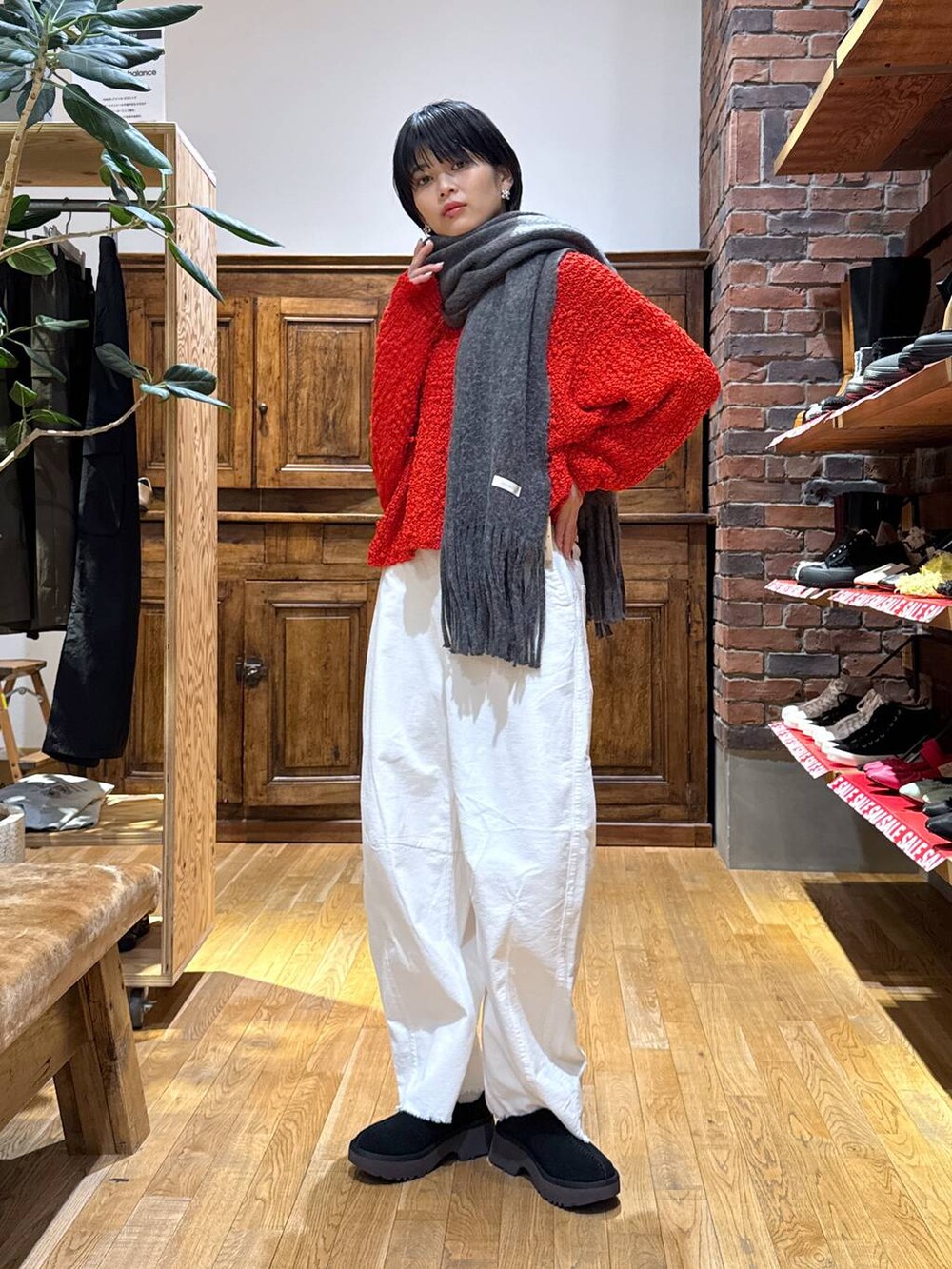 ブラック系のその他シューズ、ホワイト系のその他パンツ、レッド系のニット/セーターを着用したレディースの冬コーディネートの2枚目の写真