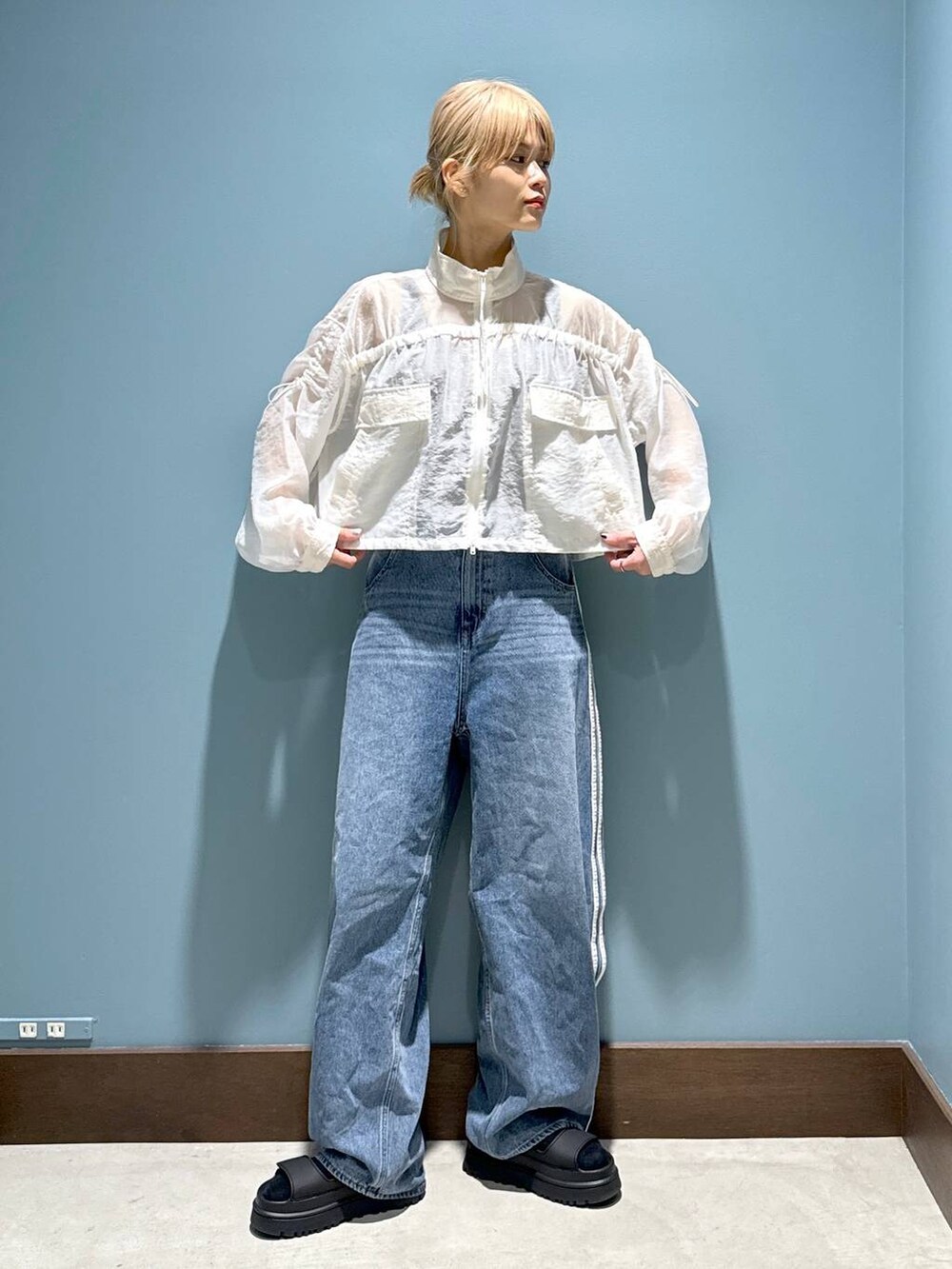 ベージュ系のタンクトップ、ホワイト系のブルゾンを着用したレディースの春コーディネートの3枚目の写真