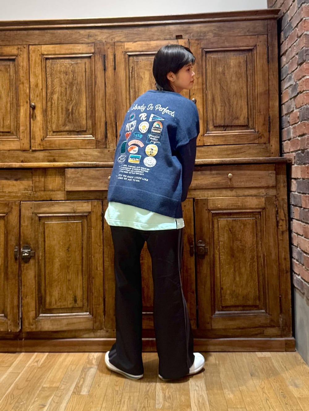 ホワイト系のブルゾン、ブルー系のニット/セーター、グリーン系のTシャツ/カットソーを着用したレディースの冬コーディネートの2枚目の写真