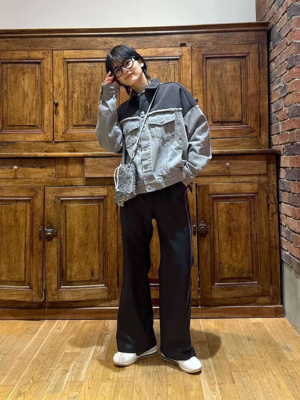 グレー系のデニムジャケット、ブラック系のショルダーバッグ、ブラック系のその他パンツを着用したレディースの冬コーディネートの3枚目の写真