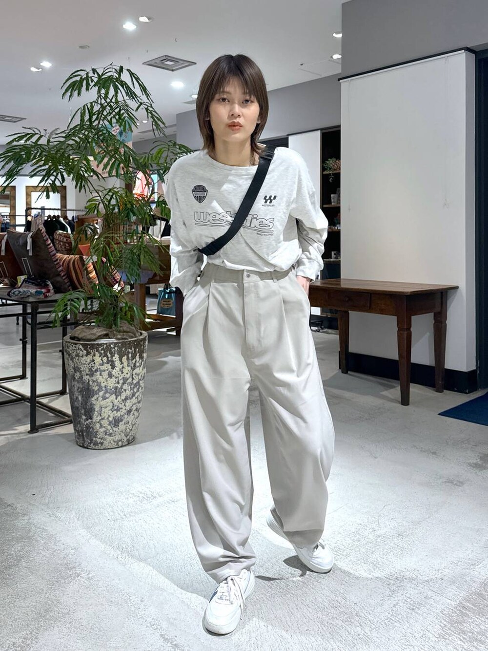 ベージュ系のTシャツ/カットソー、ベージュ系のスラックス、ブラック系のボディバッグ/ウエストポーチを着用したレディースの冬コーディネートの2枚目の写真