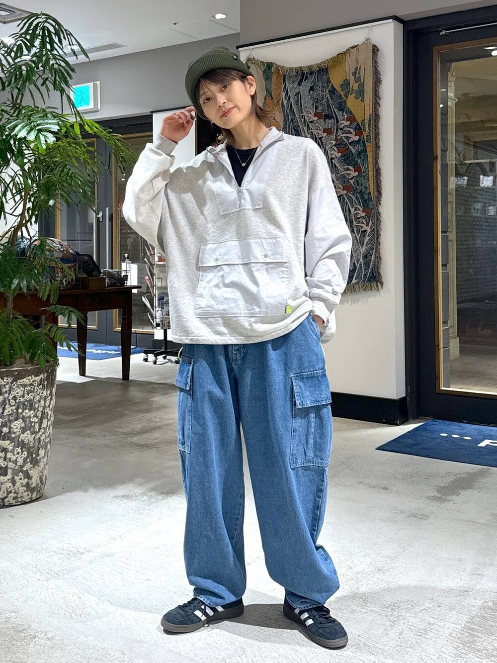 ブルー系のデニムパンツ、グリーン系のニットキャップ/ビーニーを着用したレディースの冬コーディネートの4枚目の写真