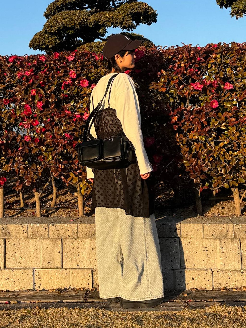 ホワイト系のTシャツ/カットソー、ブラック系のショルダーバッグ、ブラック系のワンピースを着用したレディースの冬コーディネートの2枚目の写真