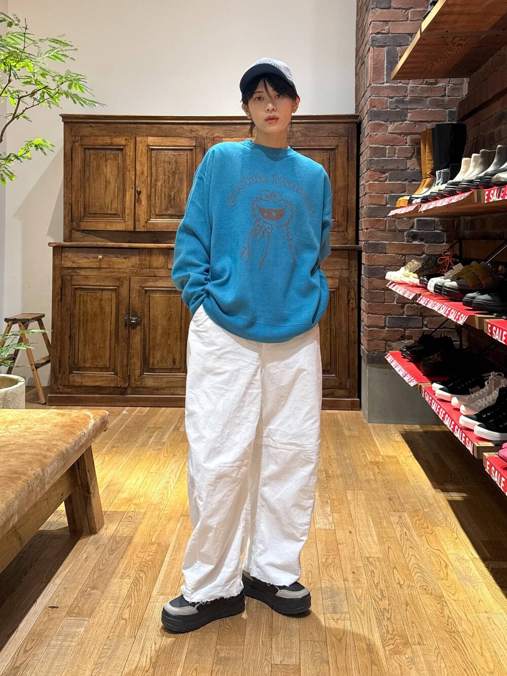 ホワイト系のその他パンツ、ブラック系のスニーカー、ブルー系のニット/セーターを着用したレディースの冬コーディネートの2枚目の写真