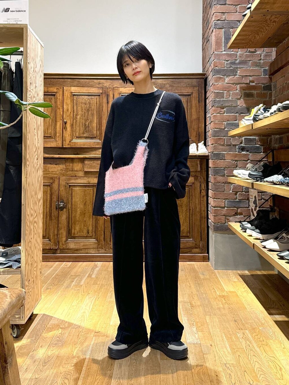 ブラック系のその他パンツ、ブラック系のニット/セーター、ブラック系のショルダーバッグを着用したレディースの秋コーディネートの2枚目の写真